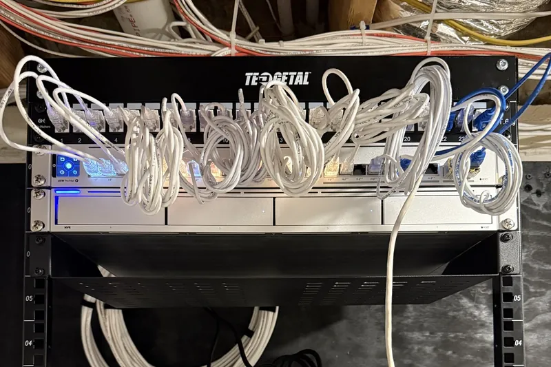 Patch panel above a UniFi switch and a camera recorder