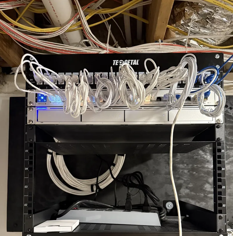 The same wall rack during install week, with long white patch cables