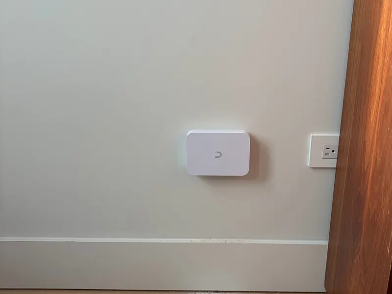 In-wall UniFi access point next to an outlet in a Park Slope house