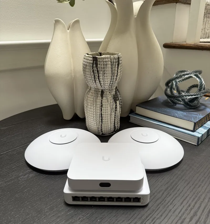 Two UniFi access points, a gateway and a switch on a dining table
