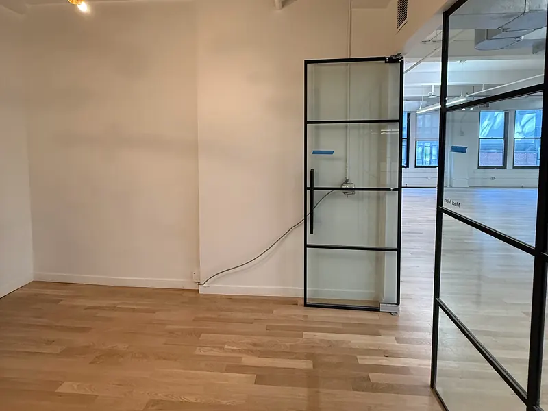 Empty renovated office floor with a glass partition and wood floors