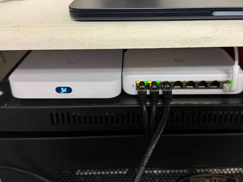 UniFi Cloud Gateway Ultra and an 8-port PoE switch on top of a network cabinet