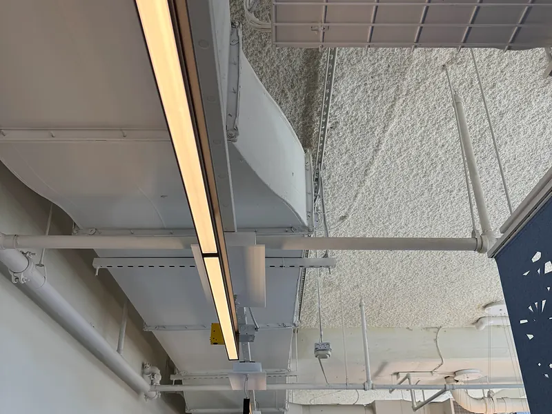 Office corridor with an overhead cable tray and exposed ceiling