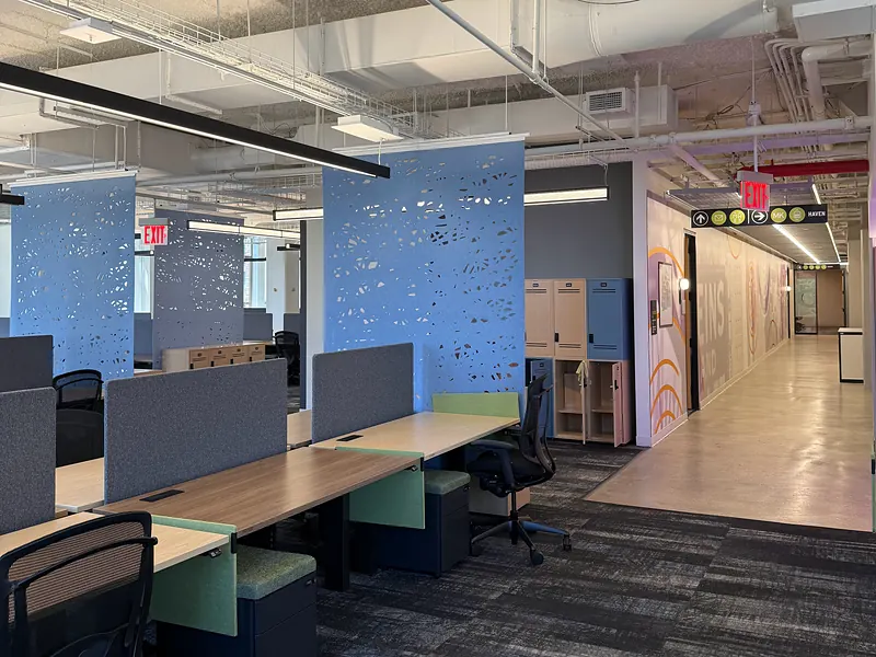 Open office with rows of desks under an exposed ceiling