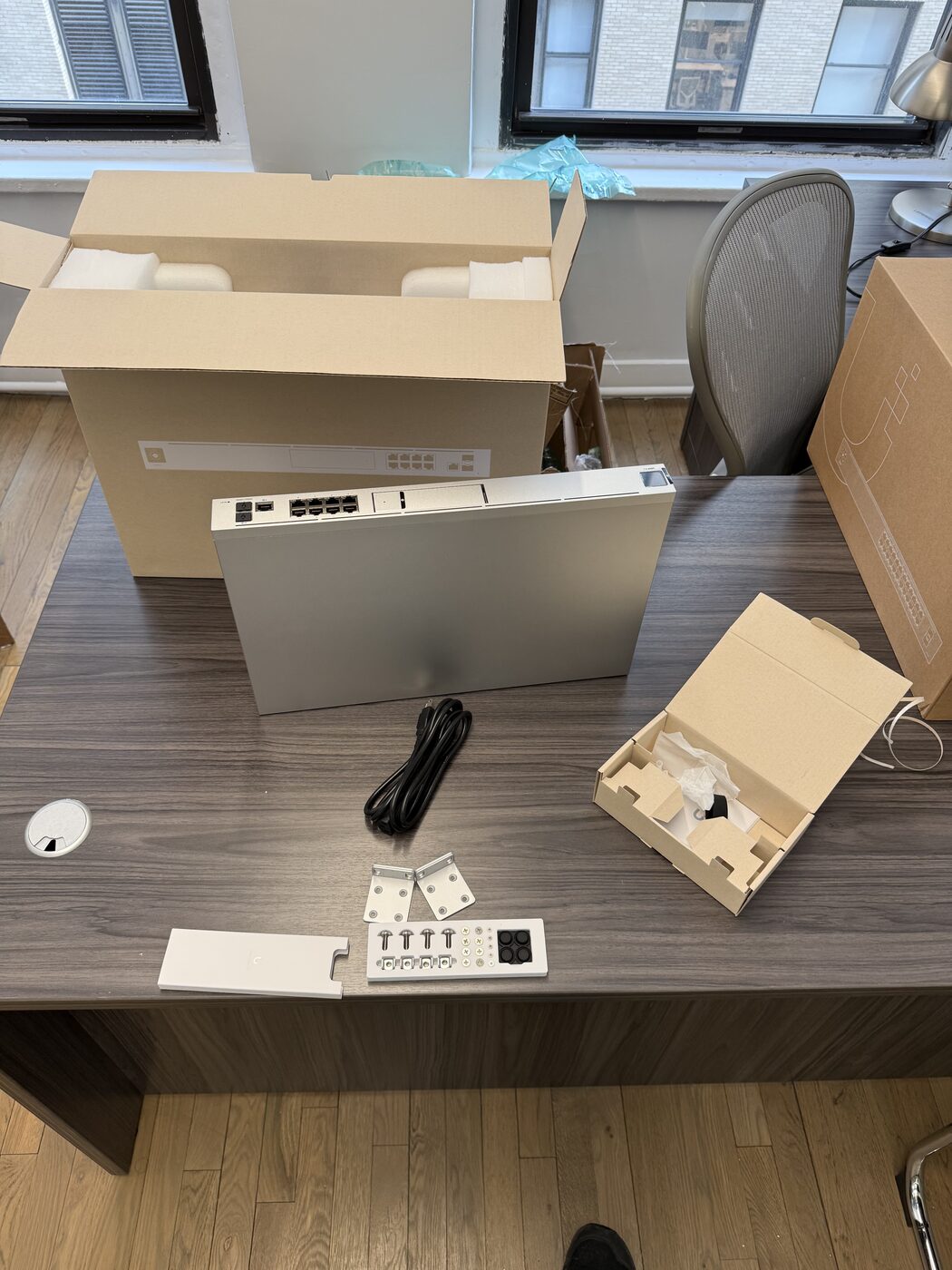 UniFi Dream Machine Pro unboxed on a desk with rack ears and power cable